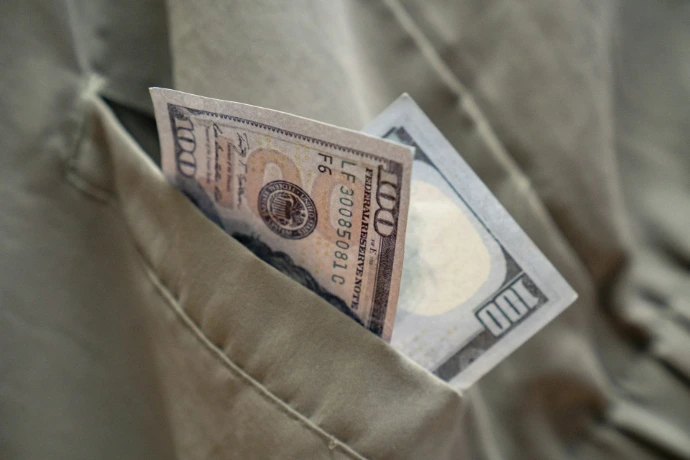 a dollar bill sticking out of a pocket